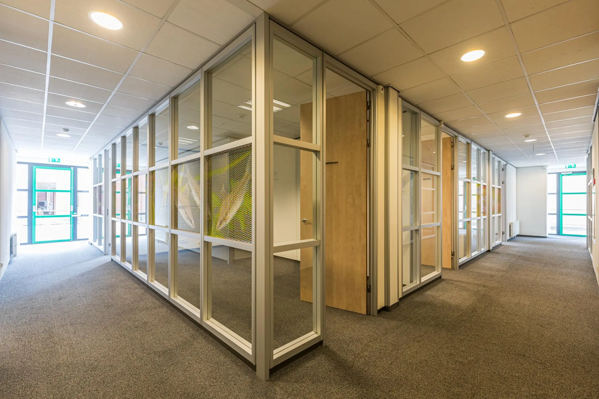 Moderne kantoorruimte aan de Laan Blussé van Oud-Alblas met glazen scheidingswanden en tapijtvloer.